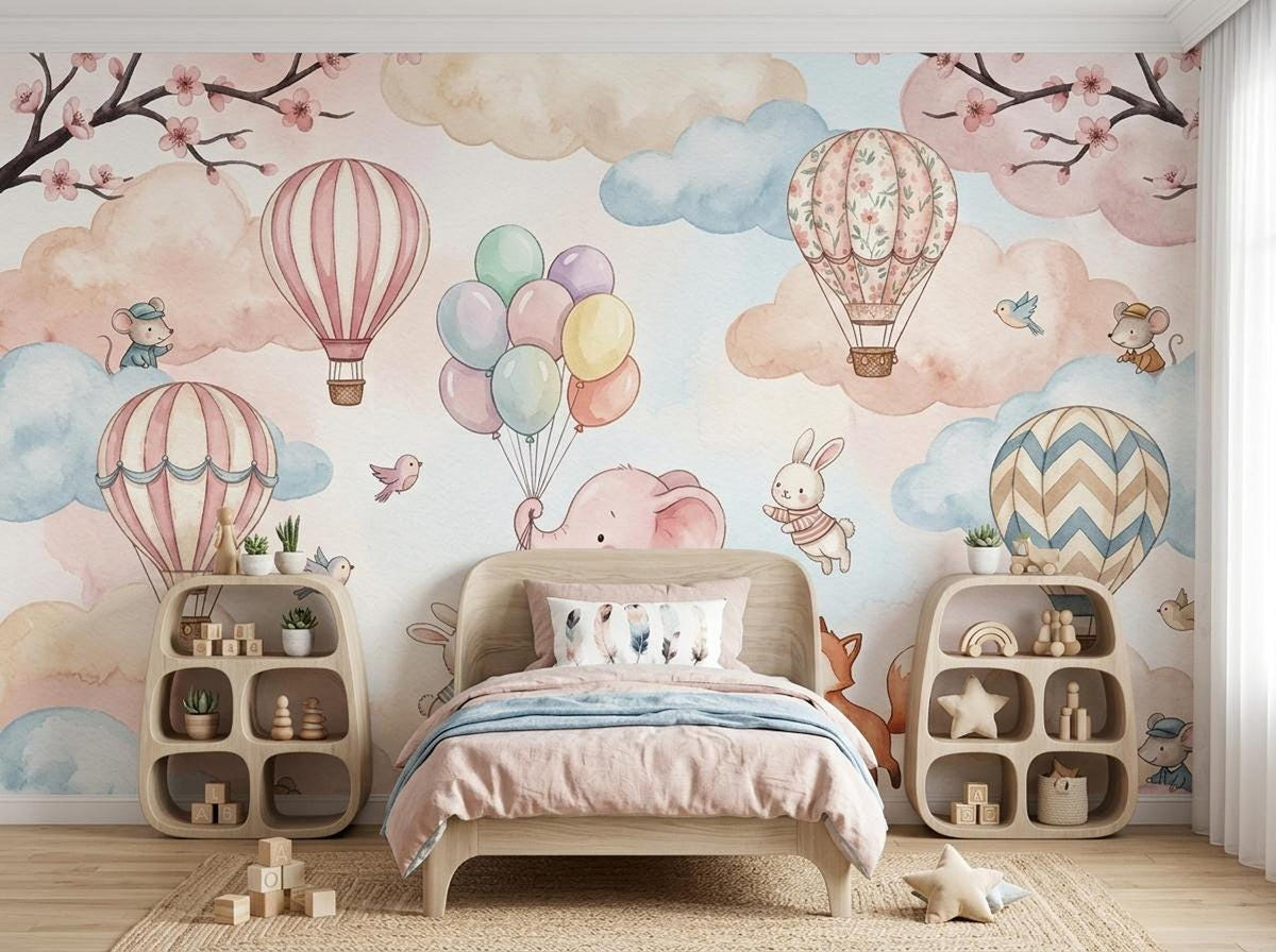 A simple bed with pink bedding sits between two curved wooden shelving units against the watercolor mural wall.