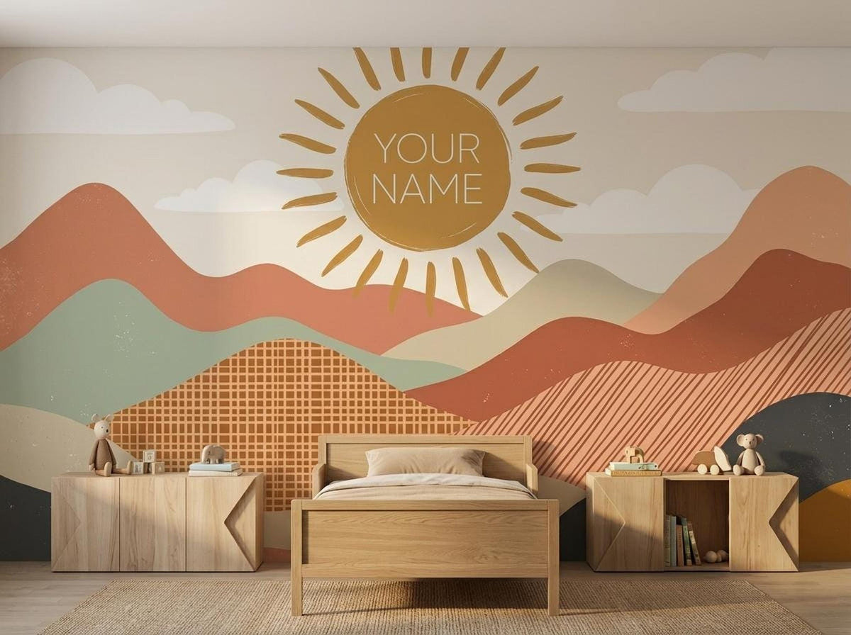 A wooden bed frame is positioned between two low wooden cabinets in front of a boho sun and mountain wall mural with YOUR NAME.