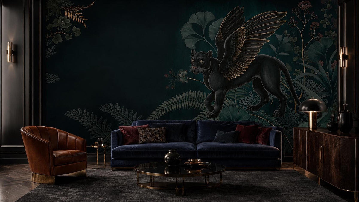 A living room with a dark green wall mural featuring a winged black panther surrounded by botanical elements, a blue velvet sofa, and a brown leather armchair.