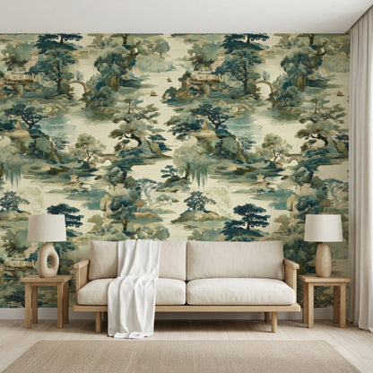 A light beige sofa with a white throw blanket stands against a Chinoiserie landscape wallpaper with matching side tables and lamps.