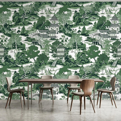 A dining room features a modern wooden table and minimalist chairs against a green chinoiserie wallpaper wall.