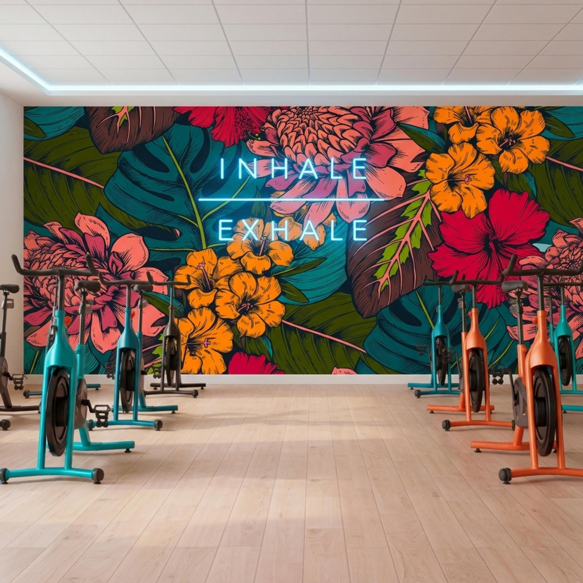 An indoor cycling studio has a dark tropical floral accent wall with neon text reading Inhale Exhale above several exercise bikes.