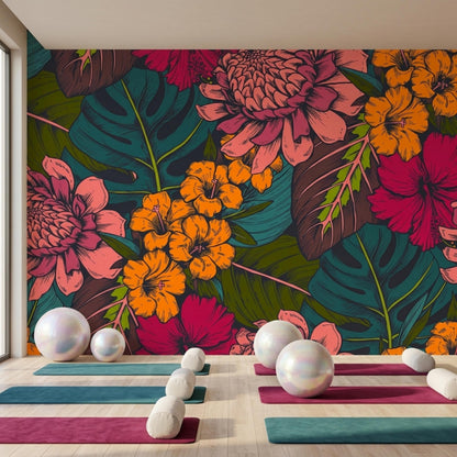 A yoga studio features colorful mats and bolsters arranged on a wood floor in front of a dark tropical floral accent wall.