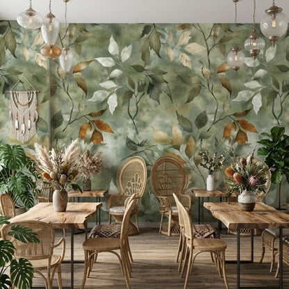A botanical sage green wallpaper mural serves as a backdrop for a dining area with wooden tables and rattan chairs.