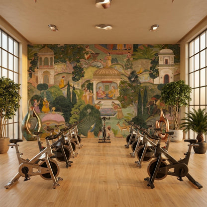 A bright indoor cycling studio features a Mughal miniature wall mural, several stationary bikes, and potted plants on a hardwood floor.