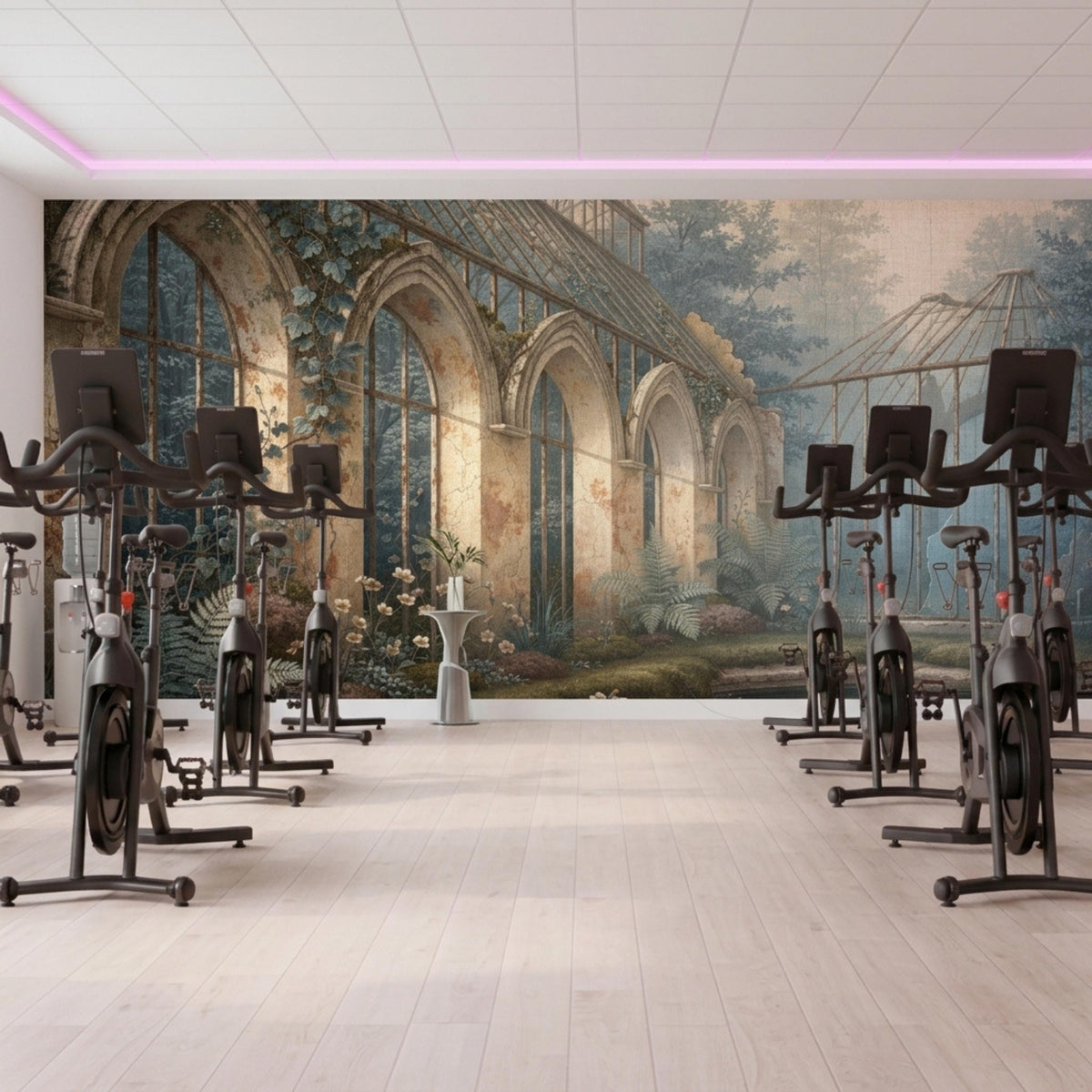 A botanical greenhouse wall mural forms the backdrop for multiple black exercise bikes lined up on a light wood floor.