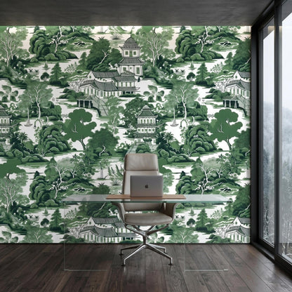 A home office features a glass desk and executive chair against a green chinoiserie pagoda landscape wallpaper wall.