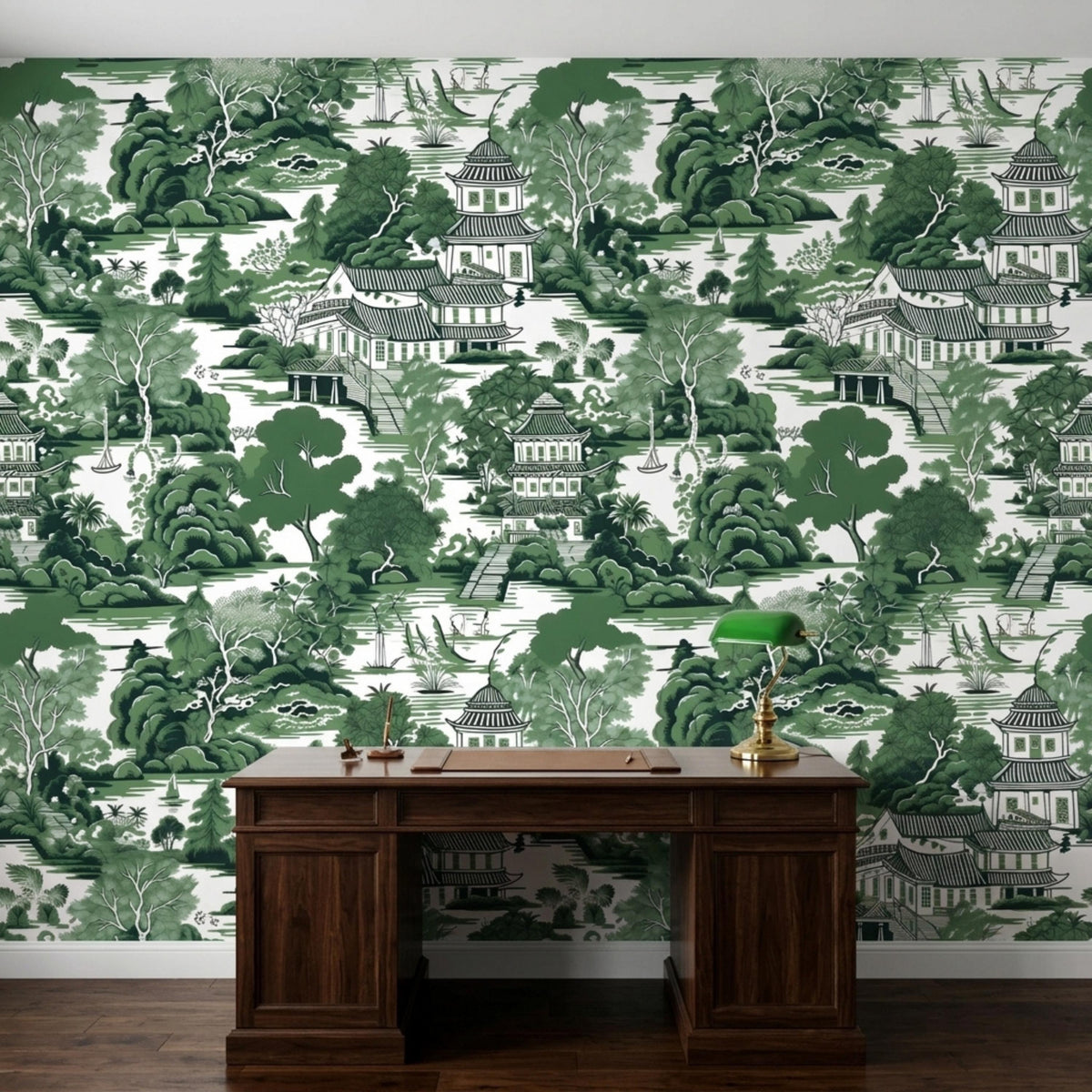 A dark wooden desk sits against a wall covered in green chinoiserie pagoda landscape wallpaper.