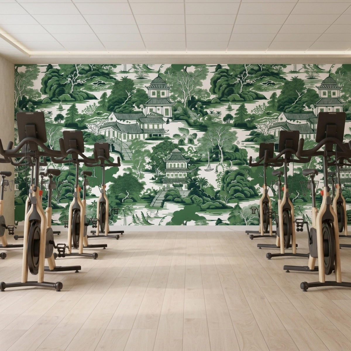 A fitness room features multiple stationary bikes lined up in front of a green chinoiserie wallpaper wall.