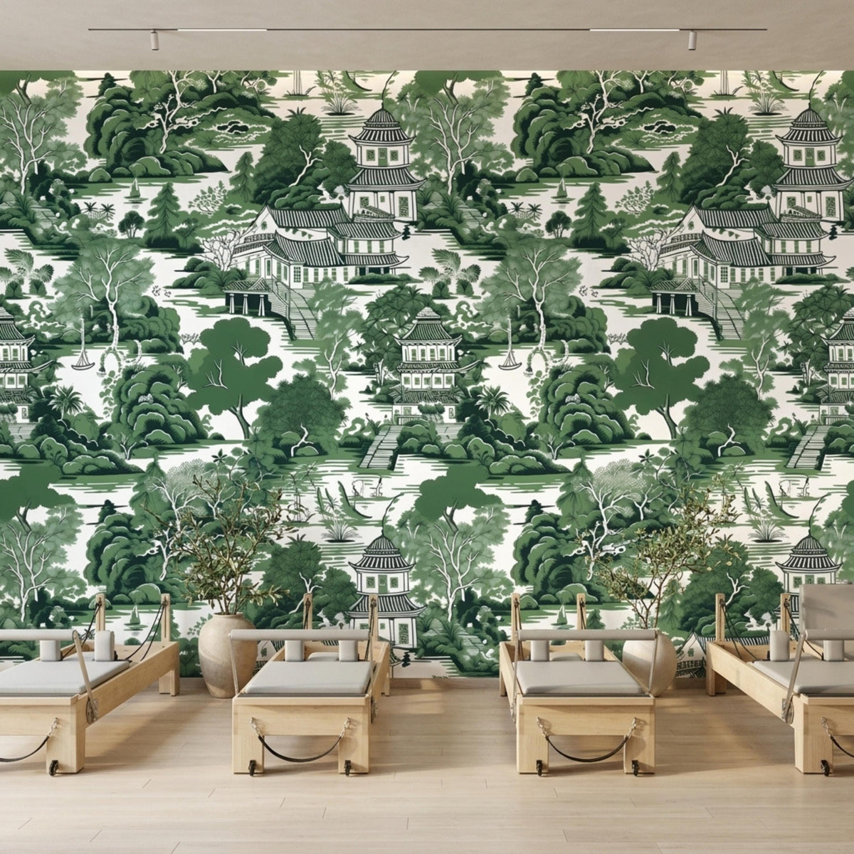 Spa treatment tables and potted plants are arranged in front of a green chinoiserie pagoda wallpaper wall.