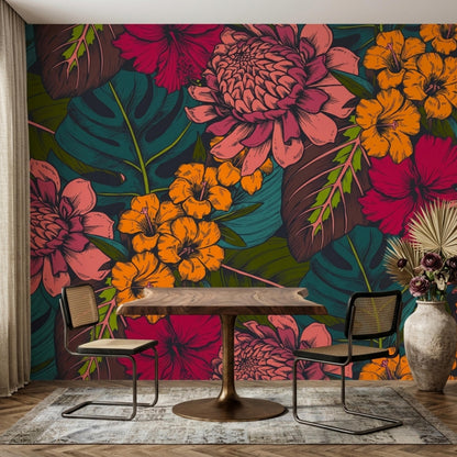 A wooden table and two woven chairs sit on a patterned rug in front of a bold tropical floral wallpaper mural.