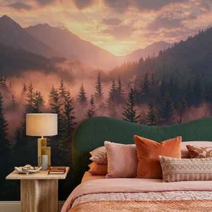 A bedroom set with a green headboard and peach bedding positioned in front of a wall mural depicting a misty sunrise over pine trees and mountains.