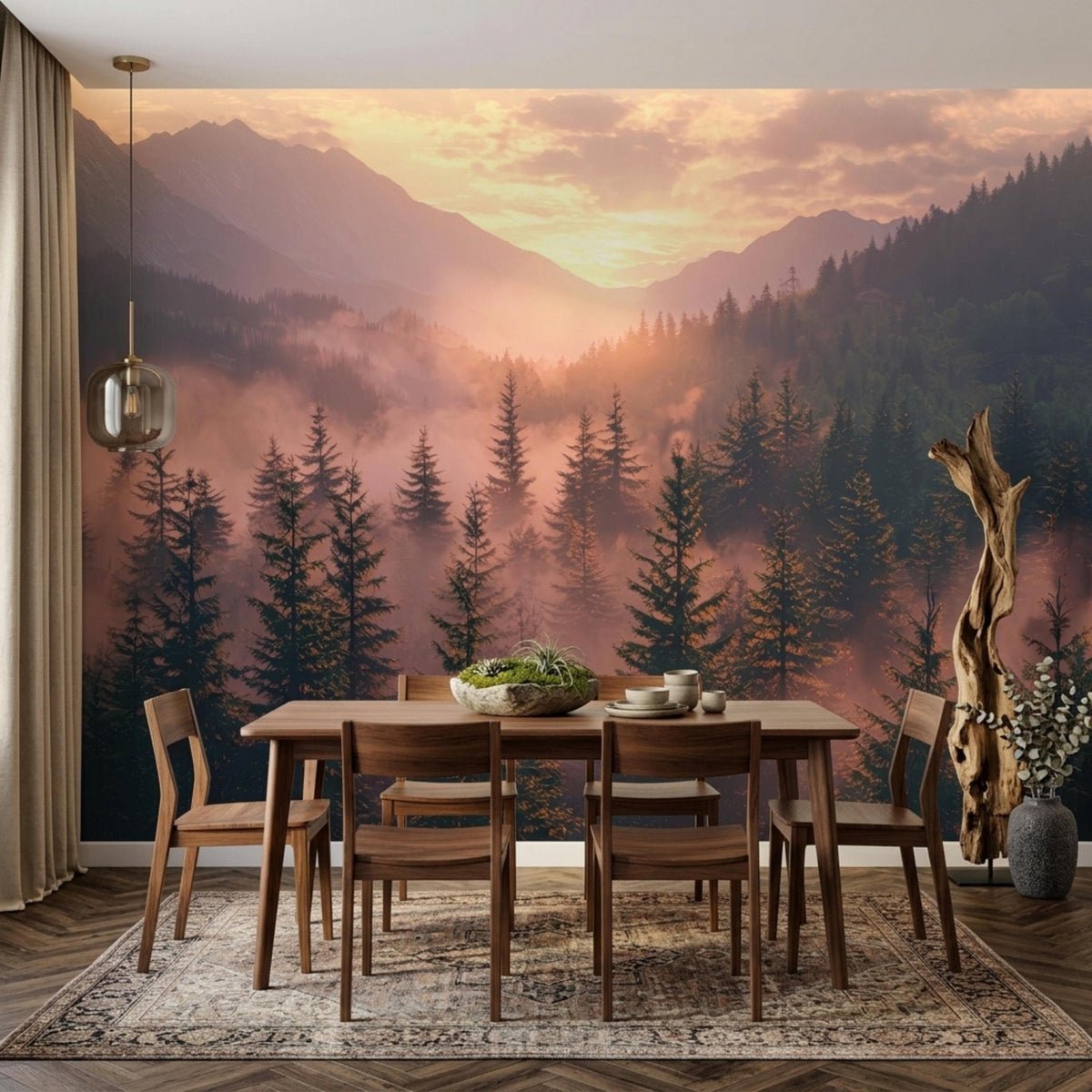 A dining area with a wooden table and chairs set against a large wall mural of a misty pine woodland and distant mountains at sunset.