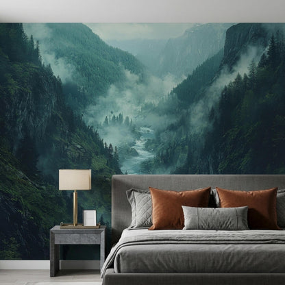 A grey bed with orange and grey pillows sits against a wall featuring a large misty mountain river valley mural.