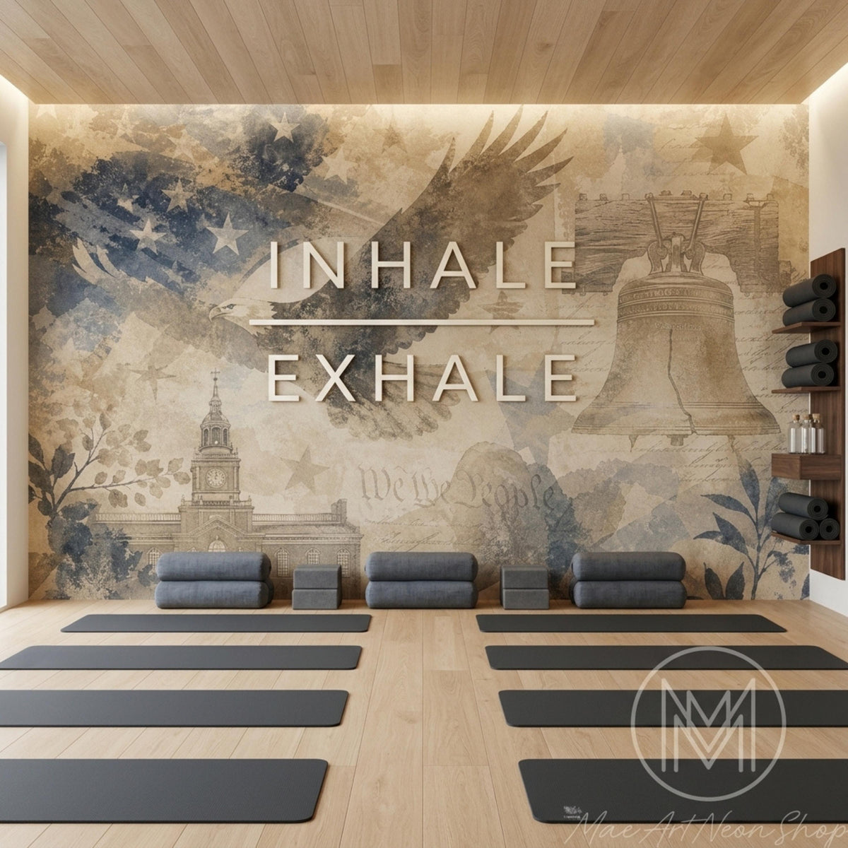 A yoga studio has multiple black mats on a light wood floor in front of a patriotic wall mural with glowing text.