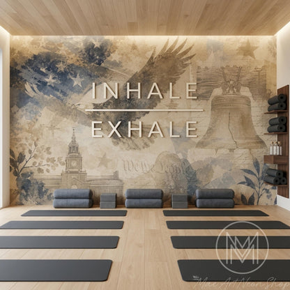 A yoga studio has multiple black mats on a light wood floor in front of a patriotic wall mural with glowing text.