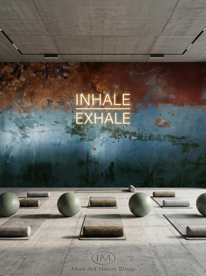 A yoga studio floor with mats and exercise balls in front of a distressed copper and blue wall mural with glowing neon text.