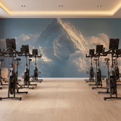 A gym with hardwood floors and multiple black stationary exercise bikes in front of a mountain wall mural.