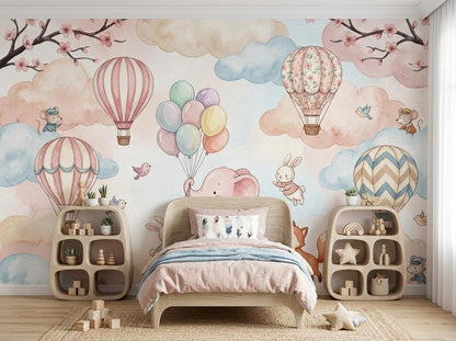 A simple bed with pink bedding sits between two curved wooden shelving units against the watercolor mural wall.