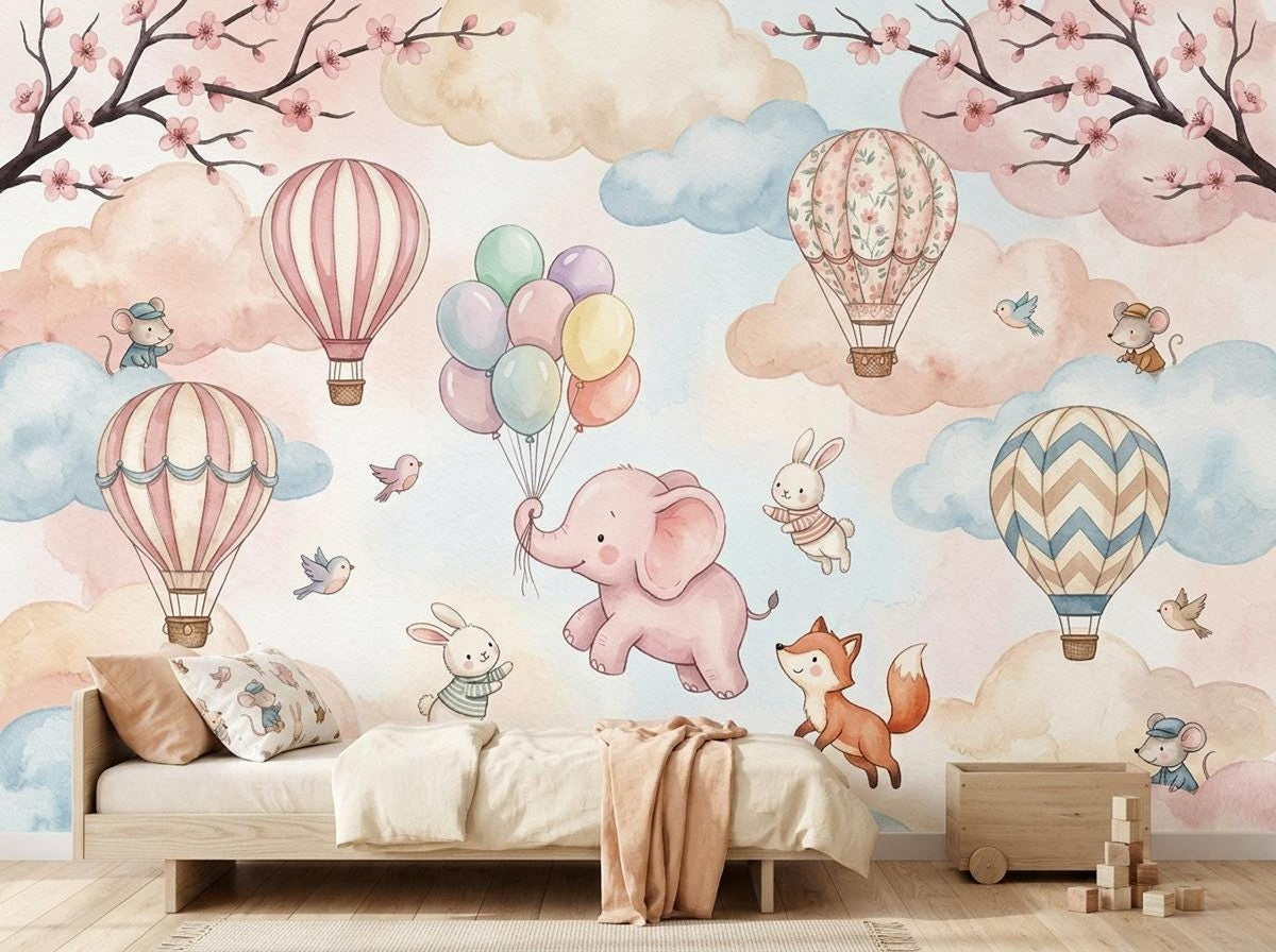 A toddler bed with patterned pillows is set against the pastel watercolor mural of animals and hot air balloons.