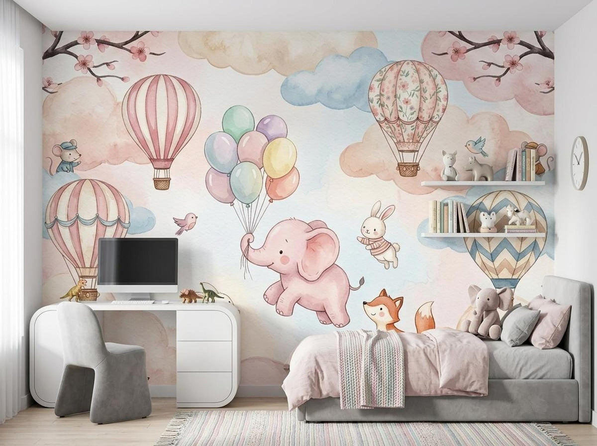 A child's bedroom features the watercolor nursery wall mural on the main wall, complete with a bed, desk, shelves, and gray chair.