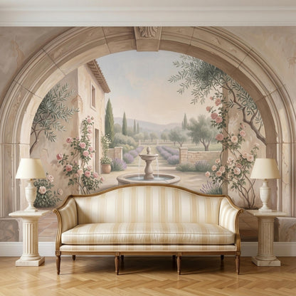 A striped upholstered sofa with two lamps on small pillars sits against a wall covered by a scenic Tuscan garden mural inside an arch.