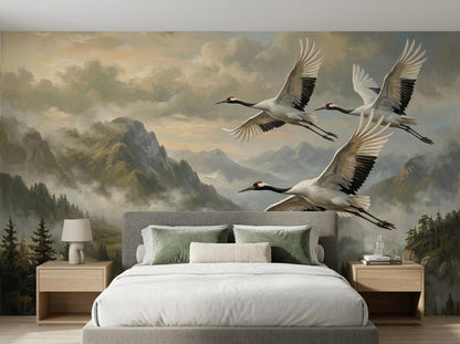 A bedroom featuring a bed with neutral bedding set against a wall mural of cranes in flight over a mountain range.