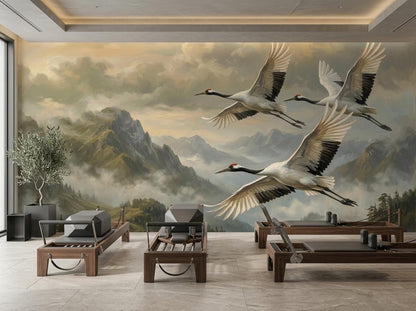 A fitness studio with pilates reformers placed against a wall mural of misty mountains and flying cranes.