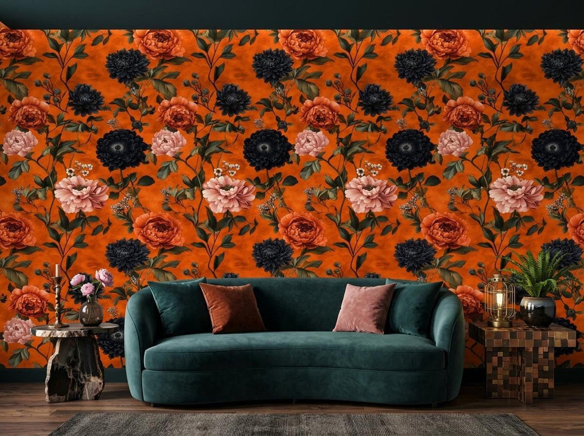 A living room features a dark teal curved sofa against a burnt orange wall covered in a maximalist floral wallpaper.