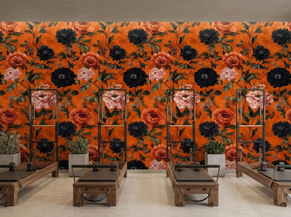 Four pilates reformers line a studio room with an accent wall of dark botanical burnt orange peony wallpaper.