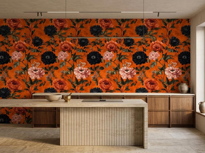 A kitchen island and wooden cabinets are positioned below a vibrant burnt orange wallpaper with large dark and pink flowers.