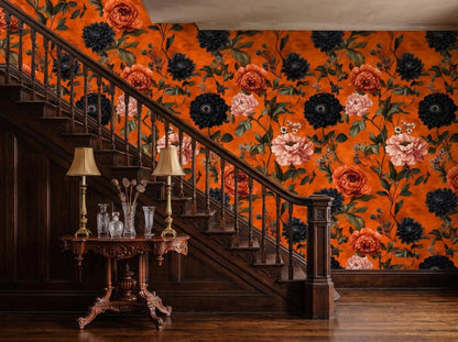 A wooden staircase with matching wainscoting sits beside a wall covered in bold orange and dark blue peony floral wallpaper.