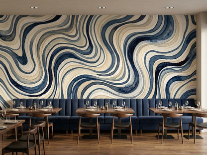 A restaurant or cafe seating area with dark blue tufted booth benches and wooden tables beneath a blue wavy wallpaper.