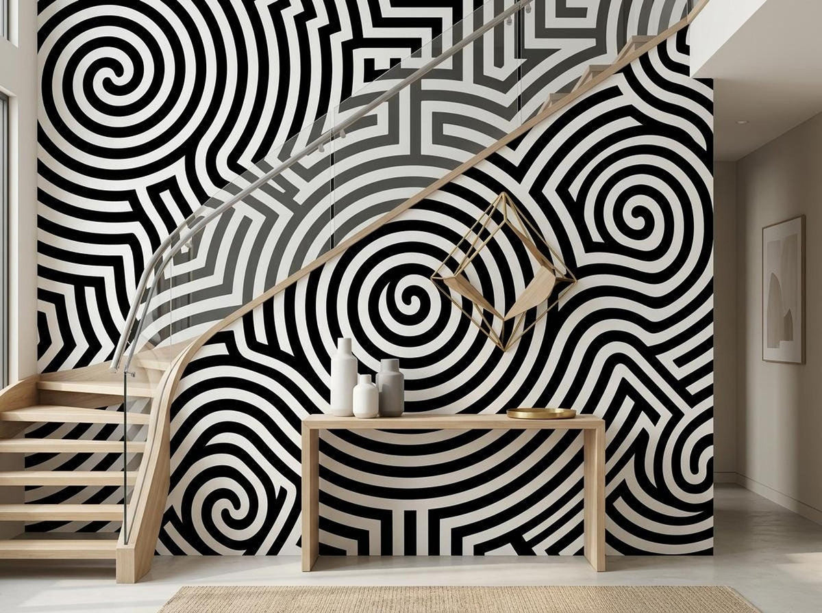 A modern hallway features a black and white spiral pattern wallpaper mural next to a wooden staircase and console table.