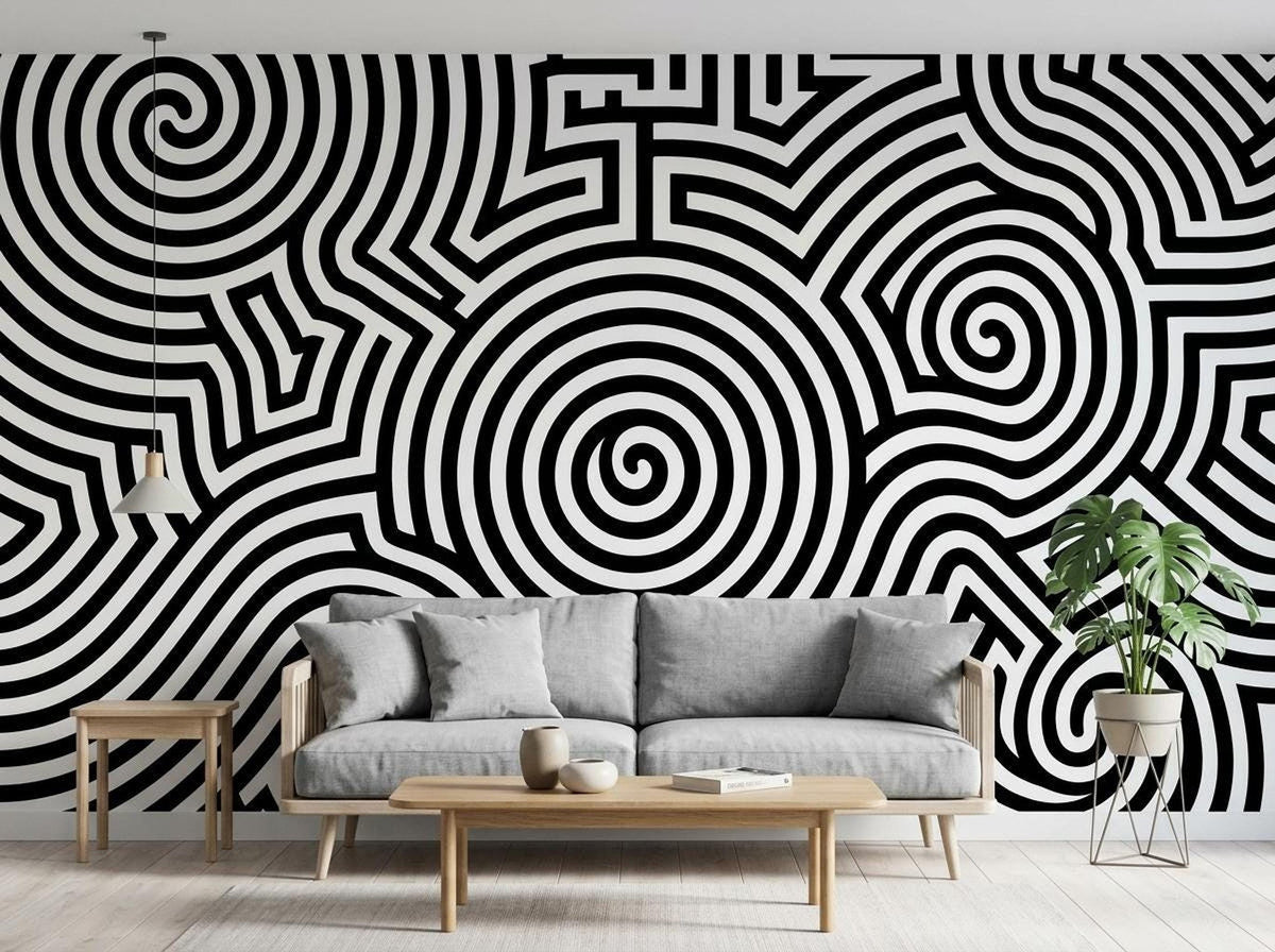 A living room interior features an accent wall with a black and white optical illusion spiral mural behind a gray sofa.