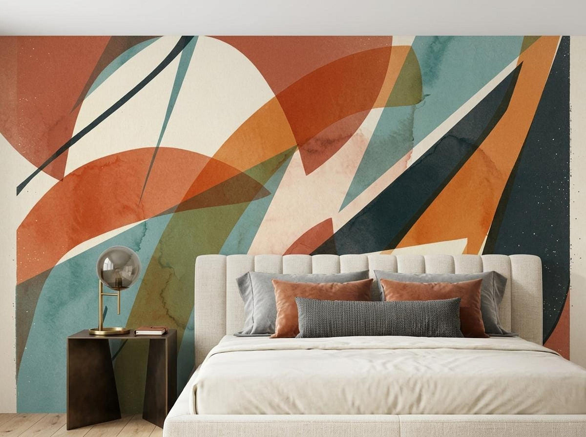 A bedroom with an abstract terracotta and teal geometric wall mural behind a tufted upholstered bed and side table.