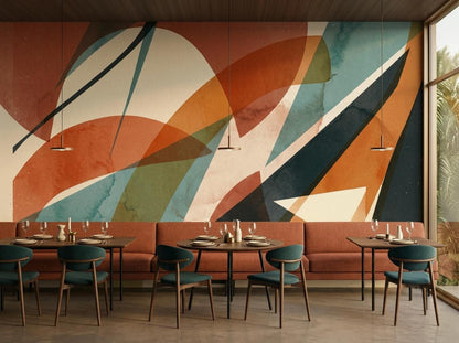 A restaurant interior featuring long orange banquette seating beneath a wide abstract geometric terracotta wallpaper mural.