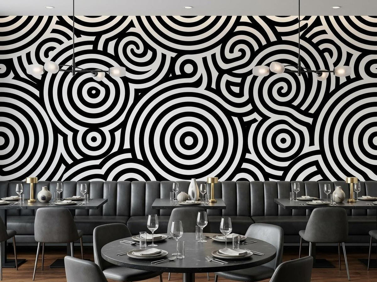 A restaurant setting with dining tables and gray seating against a striking black and white patterned feature wall.