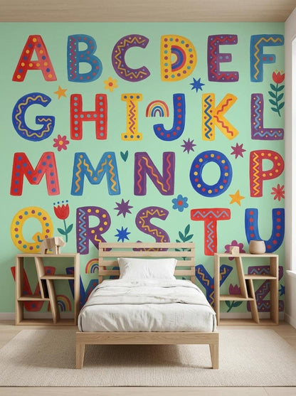 A twin bed with white bedding is framed by two wooden shelving units against a mint green wall featuring a folk art alphabet mural.