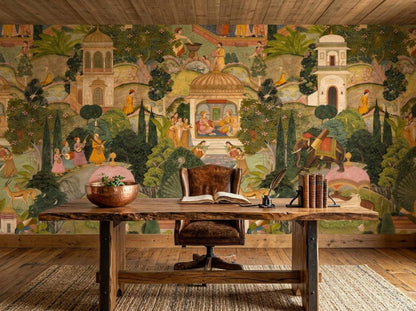 A wooden desk and chair are positioned in front of an Indian miniature painting mural wallpaper depicting a lush garden scene with figures, an elephant, and traditional buildings.