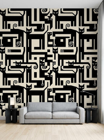 A grey sofa sits in a living room against a wall covered in graphic black and cream wallpaper featuring abstract geometric cat shapes.