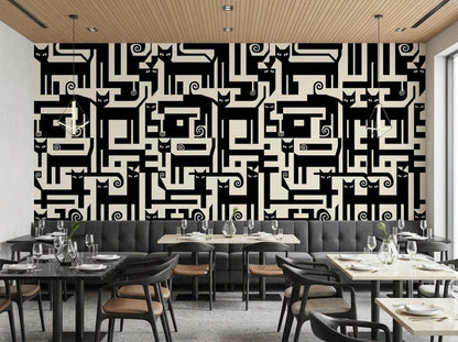 A restaurant interior shows tables, chairs, and booths backed by a large wall displaying a black and cream geometric cat wallpaper design.