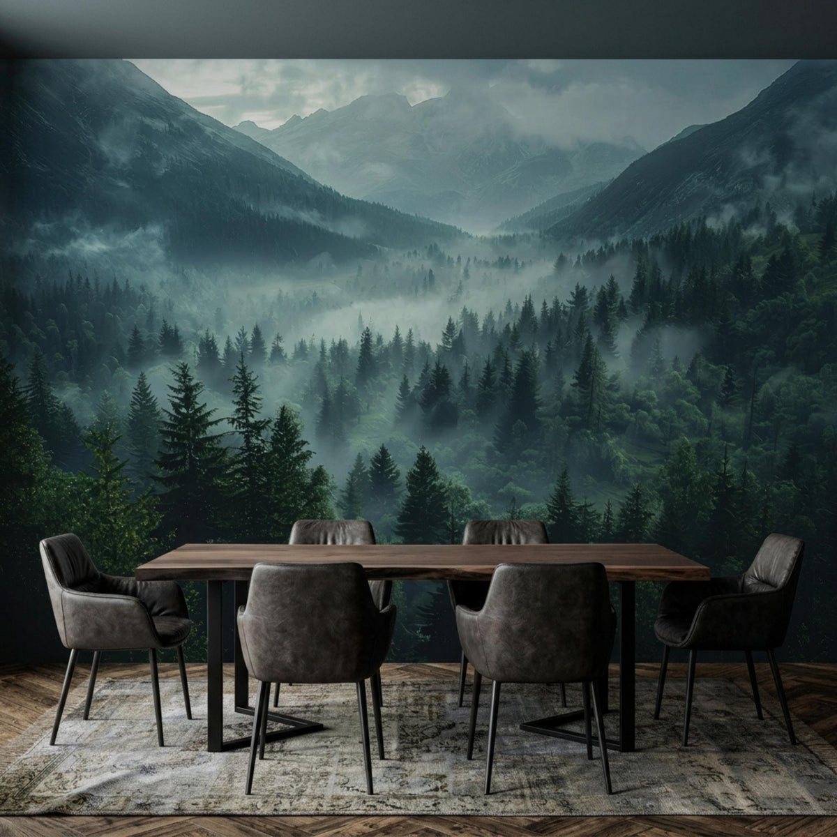 A dining table with grey chairs sits on a patterned rug in front of a misty mountain and dark pine forest wall mural.