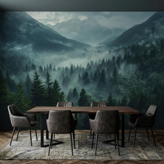 A dining table with grey chairs sits on a patterned rug in front of a misty mountain and dark pine forest wall mural.