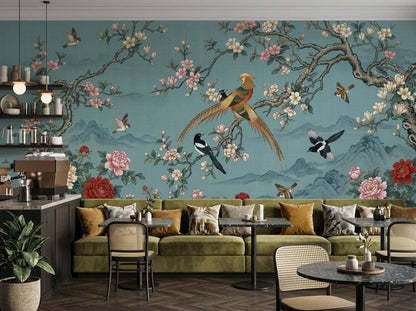 The teal chinoiserie wallpaper mural installed behind a restaurant seating area with olive green booths and small tables.