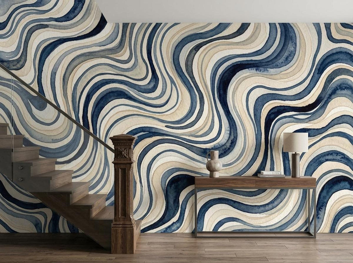 A modern staircase and console table sit in front of a blue and beige wavy watercolor accent wall.