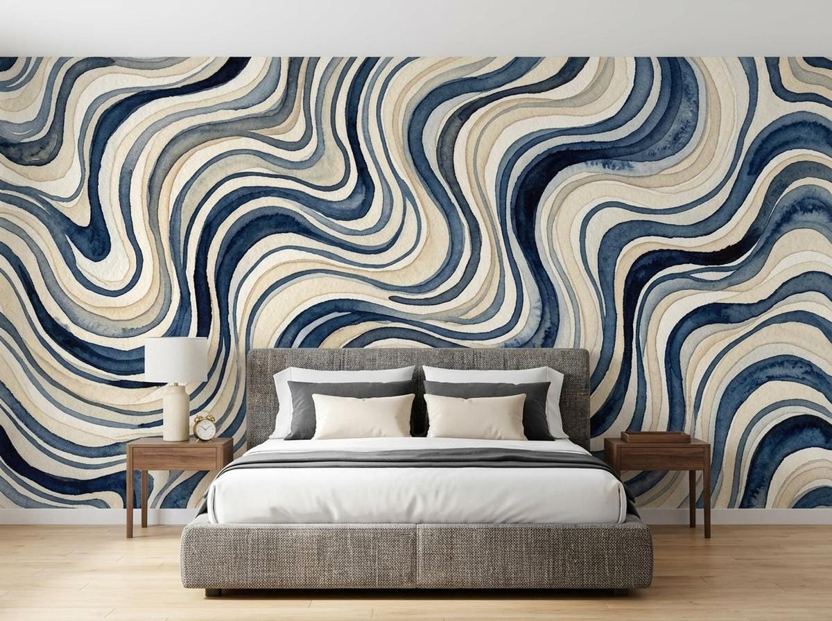 A bedroom features a fabric upholstered bed against a wall covered in blue wavy watercolor wallpaper.