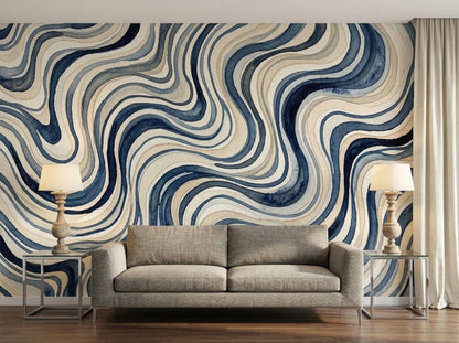 A blue abstract wavy watercolor wallpaper in a living room with a neutral sofa and lamps.