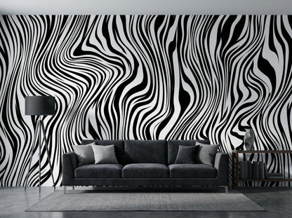 A living room interior features a black and white wavy line wallpaper accent wall behind a dark grey sofa with a lamp and rug.