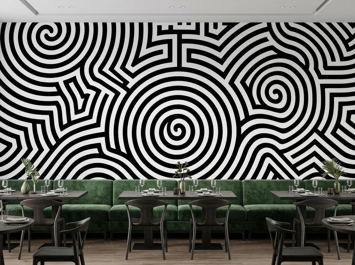 A restaurant setting showcases a bold black and white abstract spiral wall mural behind green velvet booths and tables.